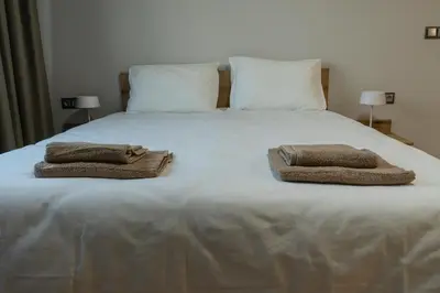 a large white bed with two towels on it at Jasmine Central Apartment in Sofia