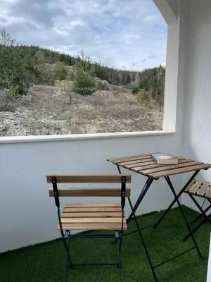a table and a bench in a room with a window at Barceló Apartment Velingrad in Velingrad