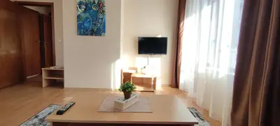 a living room with a table and a tv at Apartment SUNNY&RELAX Pamporovo The Castle 2 in Pamporovo