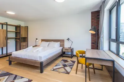 a bedroom with a bed and a table and a desk at Complex Gallery Vitosha **** in Sofia