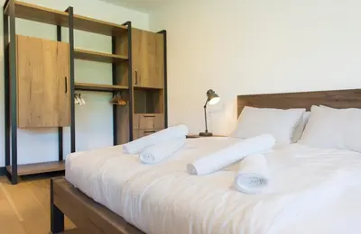 a large bed with white sheets and pillows on it at Complex Gallery Vitosha **** in Sofia