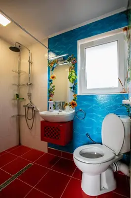 a bathroom with a toilet and a sink and a window at Къща за гости Кала in Patalenitsa