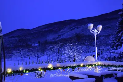 a light pole with lights in the snow at night at Къща за гости Кала in Patalenitsa