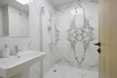 a white bathroom with a shower and a sink at Green Eyes Apartments in Sofia