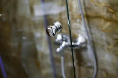 a shower with a shower knob on a wall at Hotel Leda in Sofia