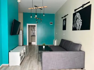 a living room with a couch and a blue wall at Flower house 4 in Sofia