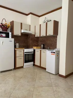 a kitchen with white appliances and brown cabinets at Luxory aparthotel in 4 star SPA hotel st Ivan Rilski, Bansko in Bansko