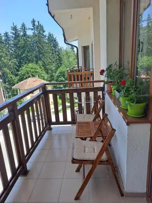 a balcony with two chairs and a view of the forest at Apartment 322, Villa Park in Borovets
