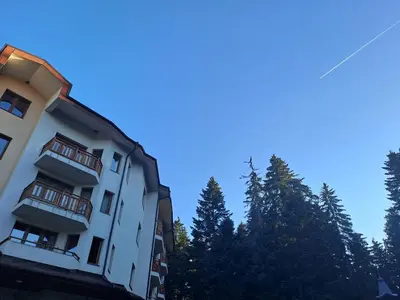 a white building with trees in the background at Apartment 322, Villa Park in Borovets