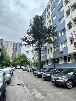 a row of cars parked in a parking lot next to a building at Flower house 7 in Sofia