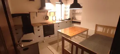 a kitchen with white cabinets and a wooden table at Marina apartment in Stoykite