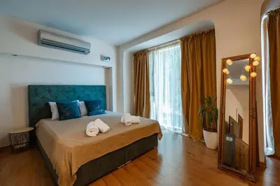 a bedroom with a large bed with towels on it at Cozy studio with FRENCH WINDOWS in Plovdiv