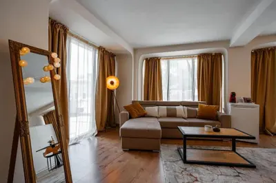 a living room with a couch and a table at Cozy studio with FRENCH WINDOWS in Plovdiv