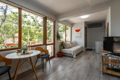 a living room with a table and a tv at Cozy Apartment Green Terrace in Plovdiv
