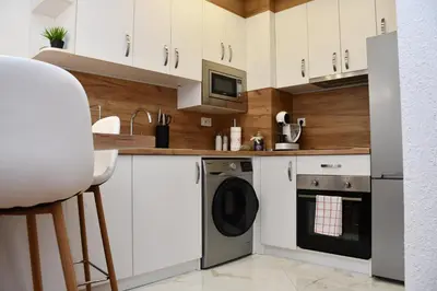 a kitchen with white cabinets and a dishwasher at Comfort 37 - Luxury ski apartment near the gondola in Bansko
