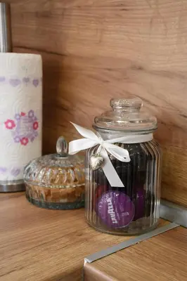 a glass jar with a bow on top of it next to a candle at Comfort 37 - Luxury ski apartment near the gondola in Bansko