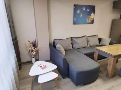a living room with a blue couch and a table at Апартамент Relax in Smolyan