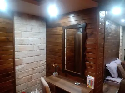 a bathroom with a wooden wall with a mirror at КръчмЪ при Байката Alpin in Ribarica