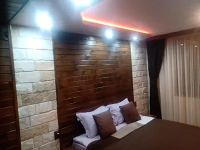 a bedroom with a brick wall and a bed with pillows at КръчмЪ при Байката Alpin in Ribarica
