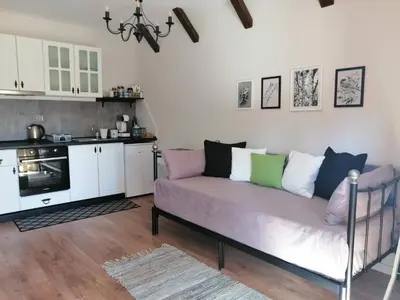 a living room with a couch and a kitchen at Студио 