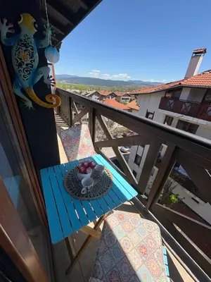 a table on a balcony with a plate of fruit on it at Boutique apartment Bansko Bell Tower in Bansko