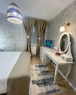a bedroom with a bed and a desk with a mirror at Boutique apartment Bansko Bell Tower in Bansko