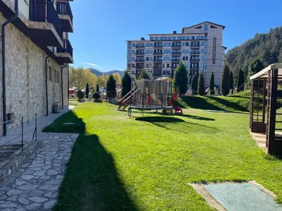 a grassy area with a playground next to a building at Мия 2 Спа хотел Свети Спас in Velingrad