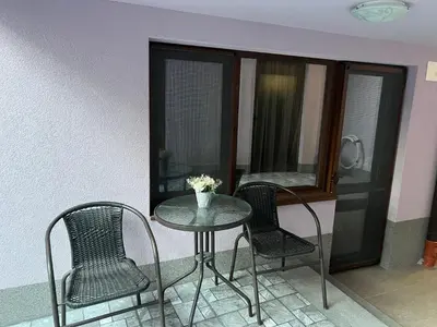 a table and two chairs and a table and a window at Guest House Tatiana Studio in Petrich