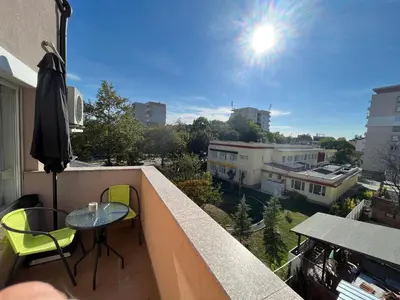 a balcony with a table and chairs and the sun at Апартамент Ламартин- в сърцето на Пловдив in Plovdiv