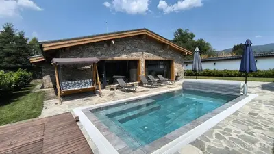 a swimming pool in front of a house at Къщи за гости Авена и Авена 2 in Banya