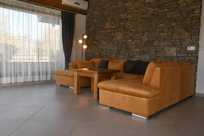a living room with a couch and a table at Къщи за гости Авена и Авена 2 in Banya