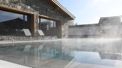 a swimming pool in front of a brick building at Къщи за гости Авена и Авена 2 in Banya