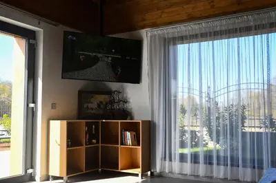 a living room with a tv and a large window at Къщи за гости Авена и Авена 2 in Banya