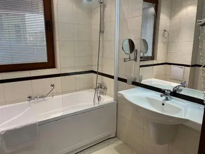 a bathroom with a tub and a sink and a bath tub at Ski & Relax Apartments in Bellevue Residence in Bansko