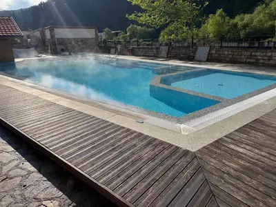 a large swimming pool with a wooden deck at Мия 3 Спа хотел Свети Спас in Velingrad