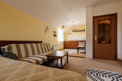 a living room with a couch and a table at Конна база и Къща за гости Дворене in Razlog