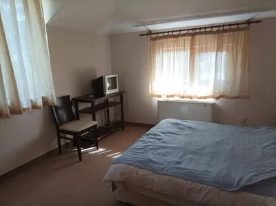 a bedroom with a bed and a tv and a chair at Конна база и Къща за гости Дворене in Razlog