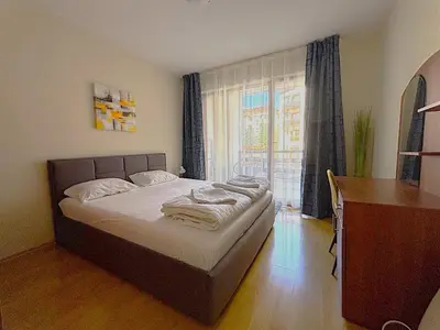 a bedroom with a bed and a desk and a window at Bansko Apartment Predela the One in Bansko