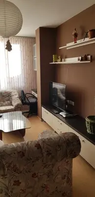 a living room with a couch and a flat screen tv at Слънчев апартамент с прекрасна гледка, паркинг. in Smolyan