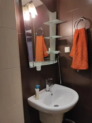 a bathroom with a sink and a mirror and towels at Слънчев апартамент с прекрасна гледка, паркинг. in Smolyan