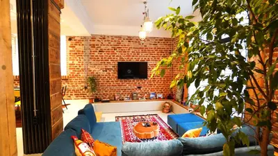 a living room with a blue couch and a brick wall at Modern and Spacious 3-Bedroom Entire House in Sofia