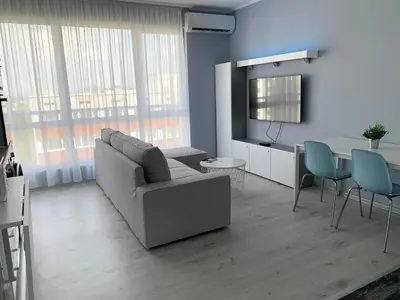 a living room with a couch and a table at Blue loft & 2bedrooms & parking in Sofia