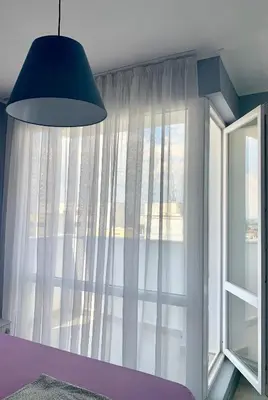 a bedroom with a large window with white curtains at Blue loft & 2bedrooms & parking in Sofia