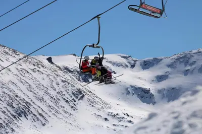 three people on a ski lift on a snow covered mountain at NEAT STUDIOS in 