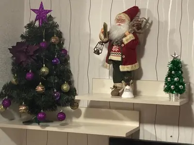 a santa claus figurine next to a christmas tree at Grand Monastery Apartment in Pamporovo