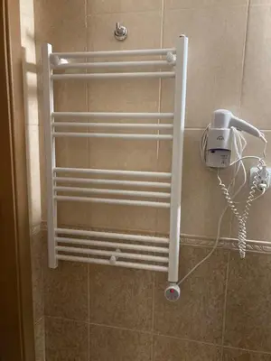 a white radiator on the wall of a bathroom at Grand Monastery Apartment in Pamporovo