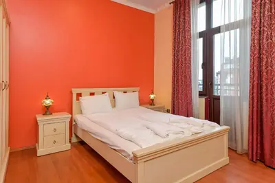 a bedroom with an orange wall and a white bed at Life in Colors - Elegant 2BD Premium Stay by Flat Mаnager in Sofia