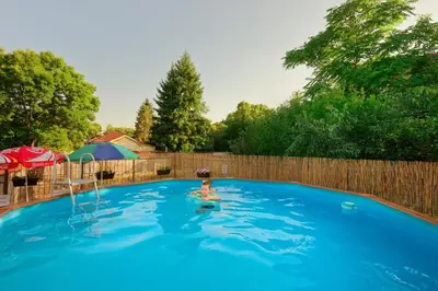 a woman in a swimming pool in a backyard at Комплекс Колонада in Hisarya