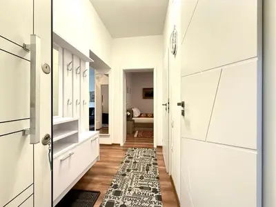 a hallway with white cabinets and a rug at A Lovely 2BR Apartment in the heart of Sofia - NDK in Sofia