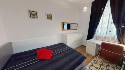 a bedroom with a bed with a red pillow on it at A Lovely 2BR Apartment in the heart of Sofia - NDK in Sofia